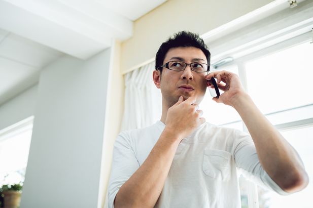 不安げに電話を受けている男性